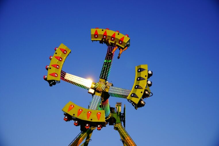 Buntes Fahrgeschäft auf einem Jahrmarkt unter blauem Himmel
