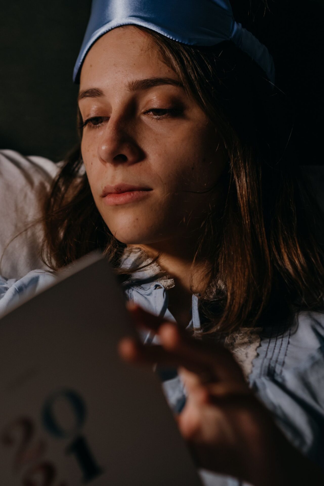 Frau liest abends im Bett ein Buch