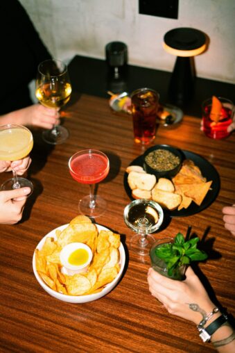 Freunde sitzen gemeinsam bei Snacks und Getränken am Tisch