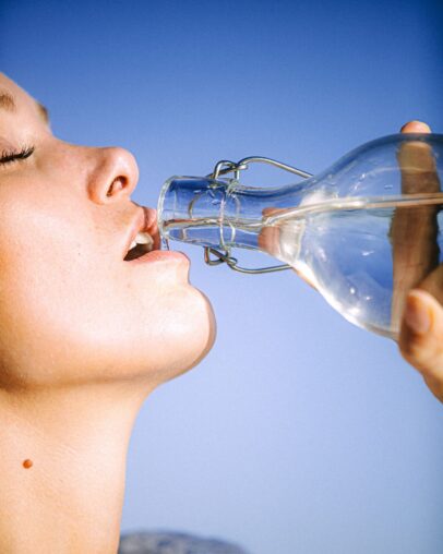 Person gießt frisches Wasser in ein Glas