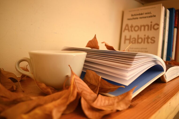 Tasse Tee und Buch auf einem herbstlich dekorierten Tisch