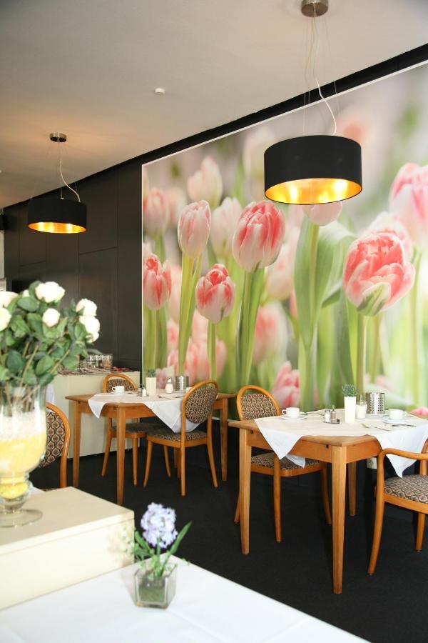 hotel-pflug-fruehstuecksraum-holztische-blumendekoration.jpg