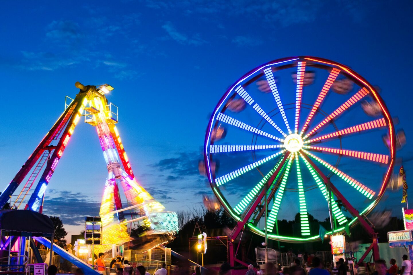 Beleuchtete Fahrgeschäfte auf einem Jahrmarkt bei Nacht