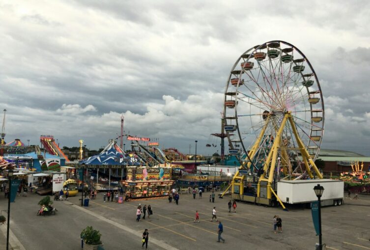 Festplatz mit Riesenrad und weiteren Fahrgeschäften