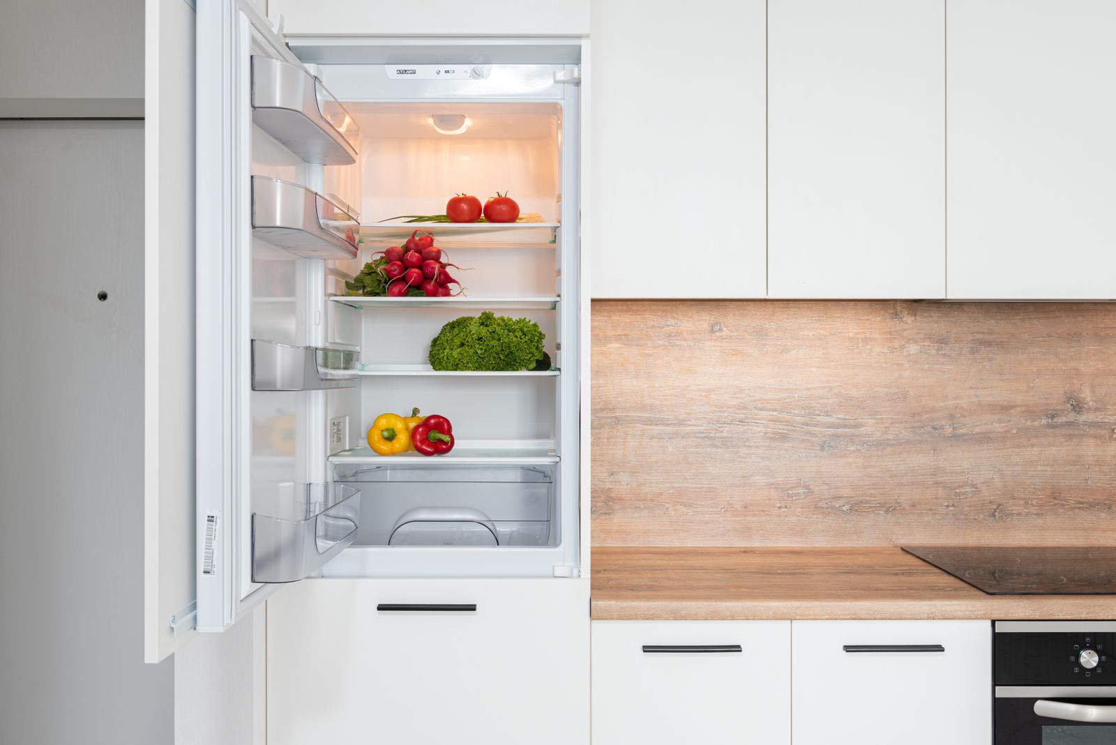 Geöffneter Kühlschrank mit frischem Gemüse und Lebensmitteln