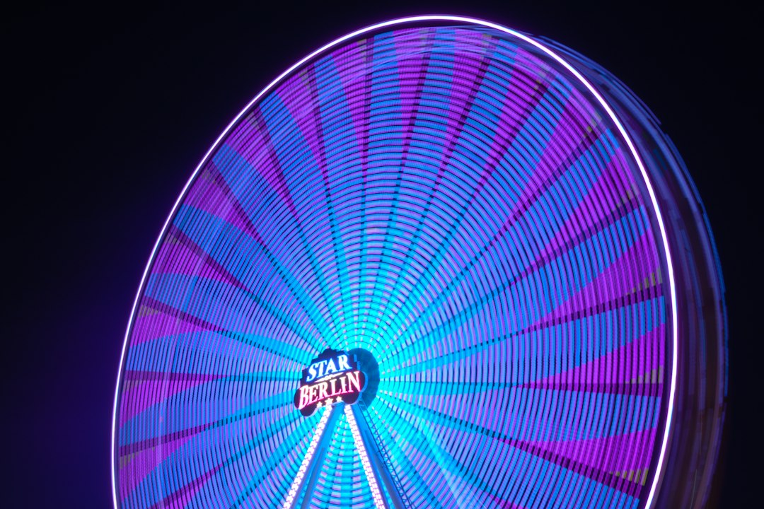 Hell beleuchtetes Riesenrad auf einem Jahrmarkt – Symbolbild