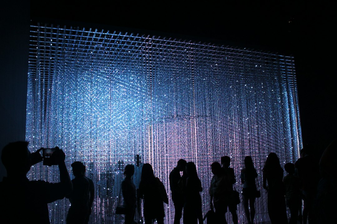 Besucher in einer Lichtkunst-Ausstellung bei Nacht als Symbolbild für das Stadtleuchten Kamen