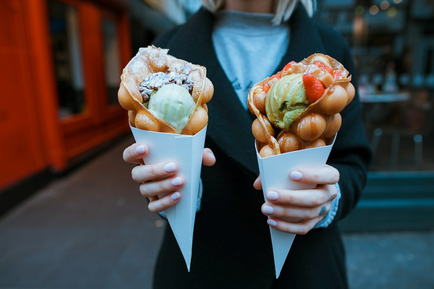Zwei süße Street-Food-Desserts werden in den Händen gehalten
