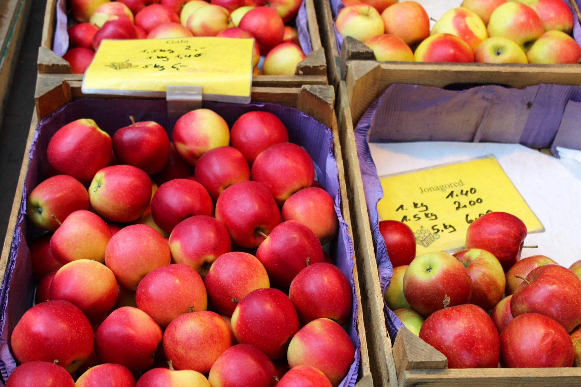 Frische und leuchtend rote Äpfel in Holzkisten, arrangiert auf dem Wochenmarkt in Petershagen.