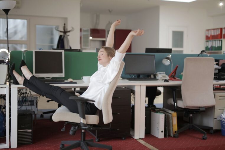 Mann dehnt sich während der Arbeit am Schreibtisch