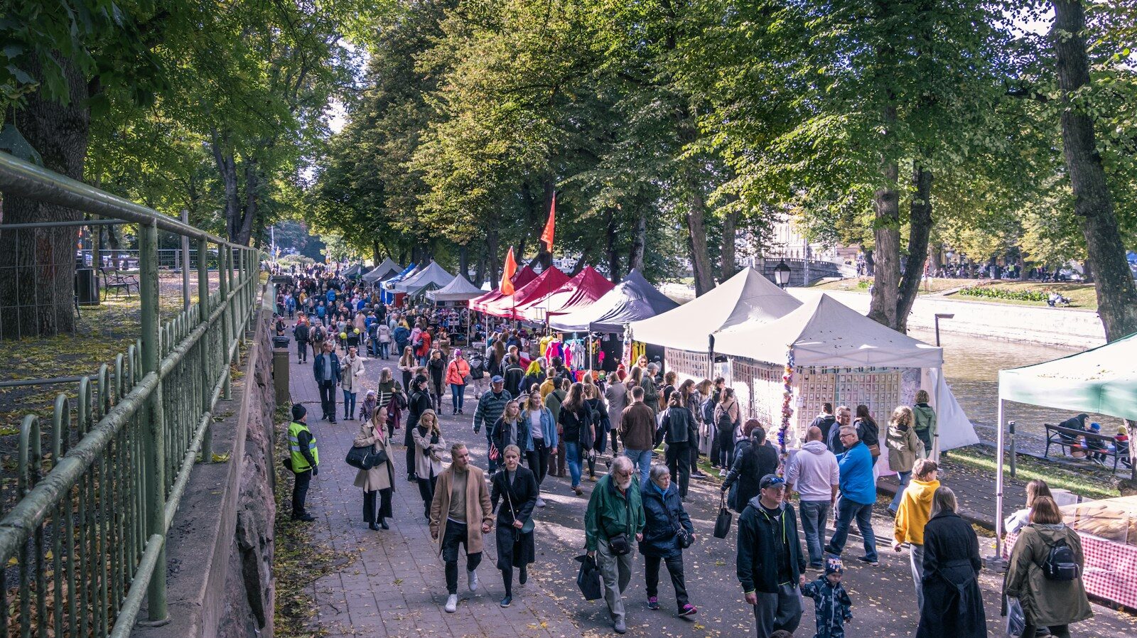 Besucher und Marktstände in einem Park als Symbolbild für den Indian Summer