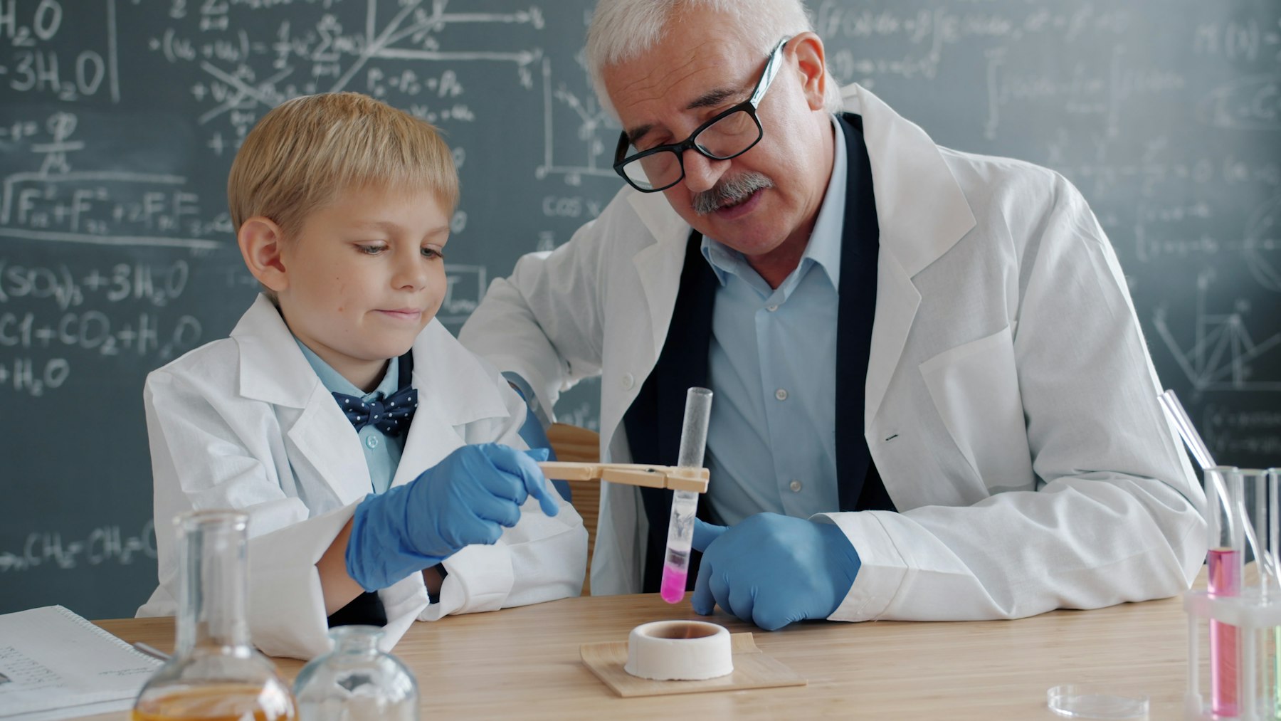 Kind und Wissenschaftler führen gemeinsam ein Experiment im Labor durch