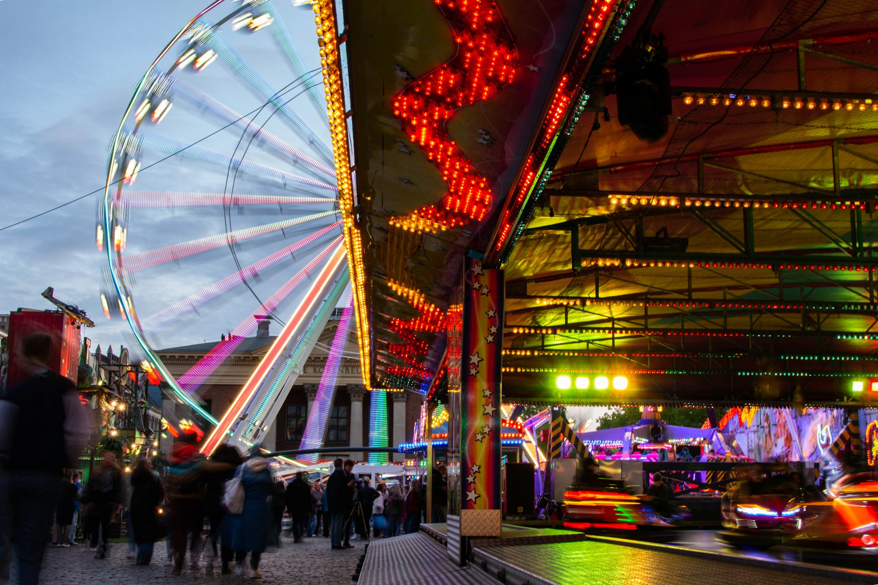 Kirmesplatz mit Riesenrad und weiteren Fahrgeschäften